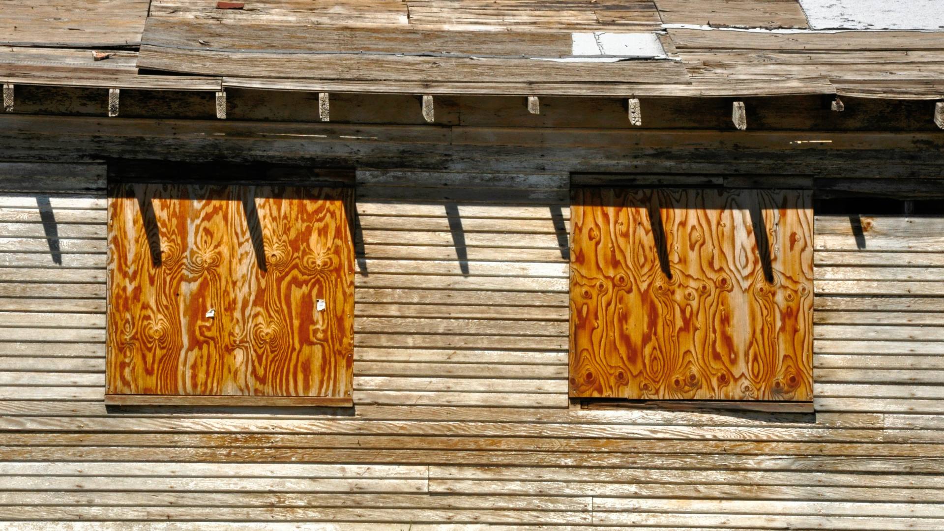 Emergency board-up securing broken windows on a building