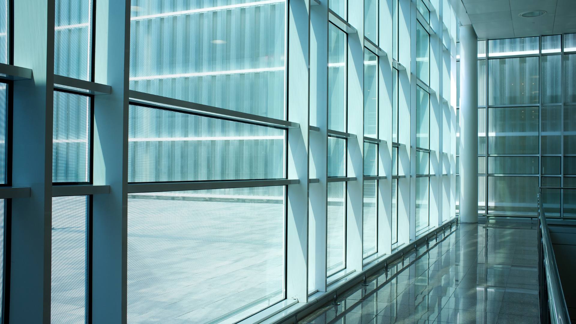 Glass partition walls lining a modern office hallway