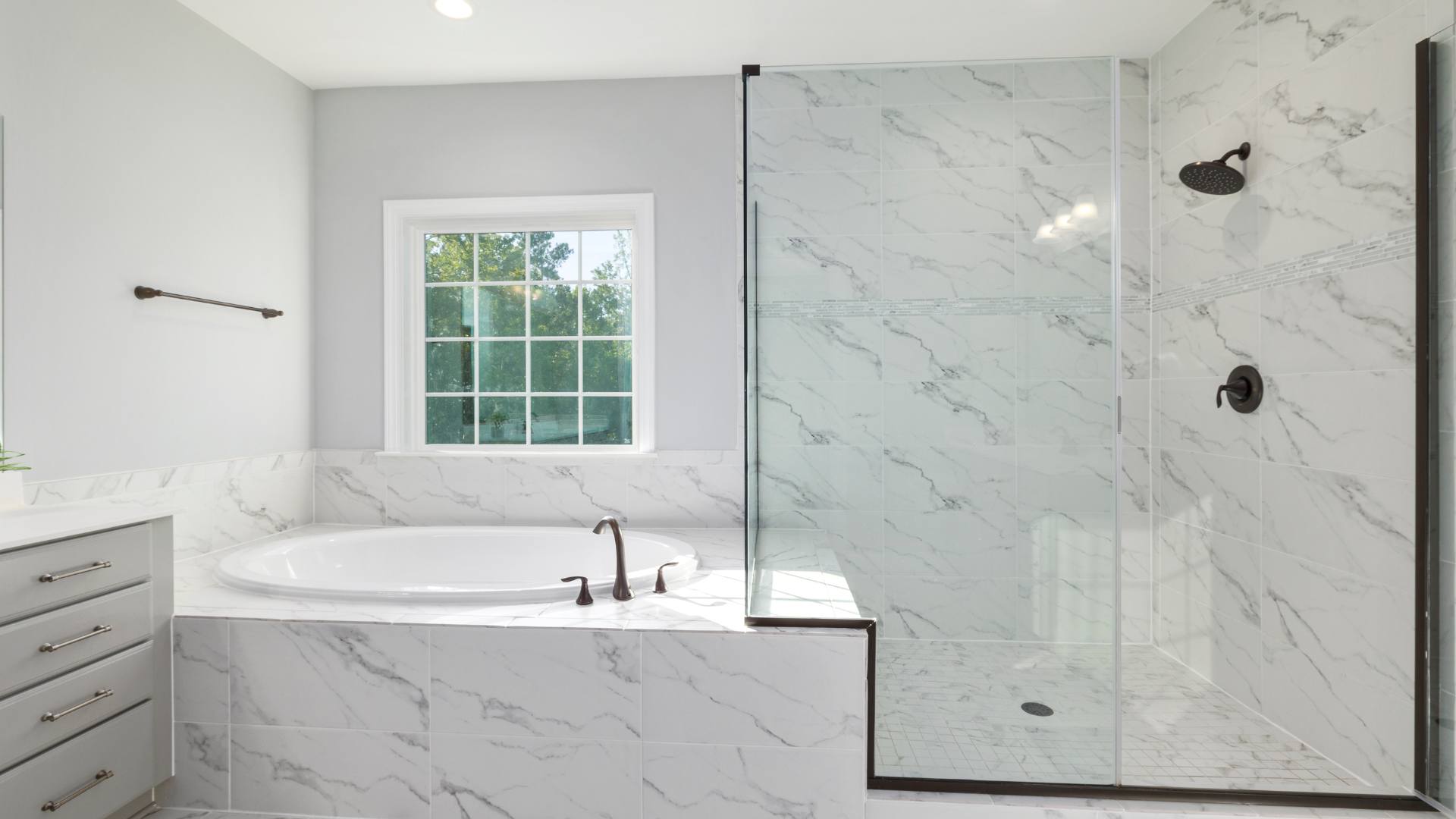 Modern frameless glass shower enclosure with a scenic view